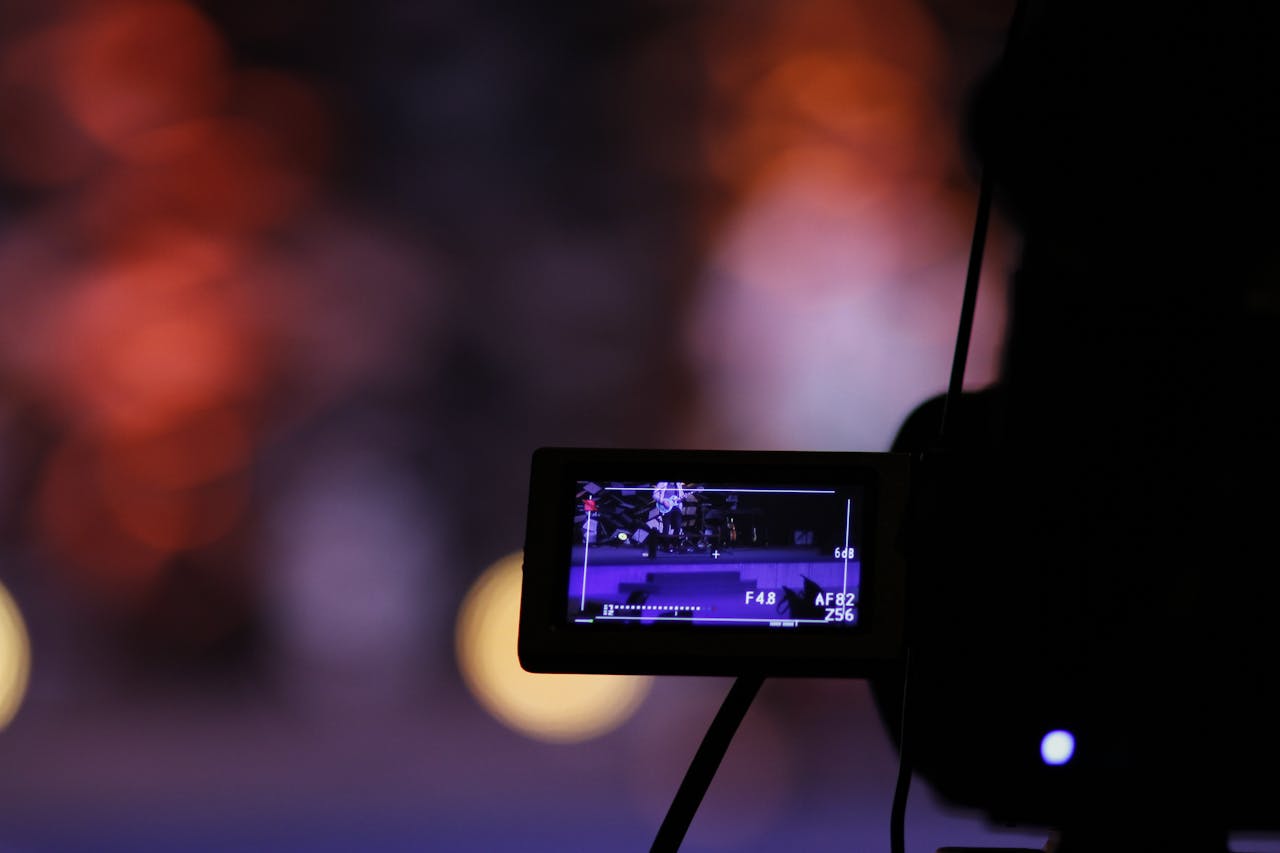 Close-up of a digital camera screen recording a scene with a vibrant bokeh background.
